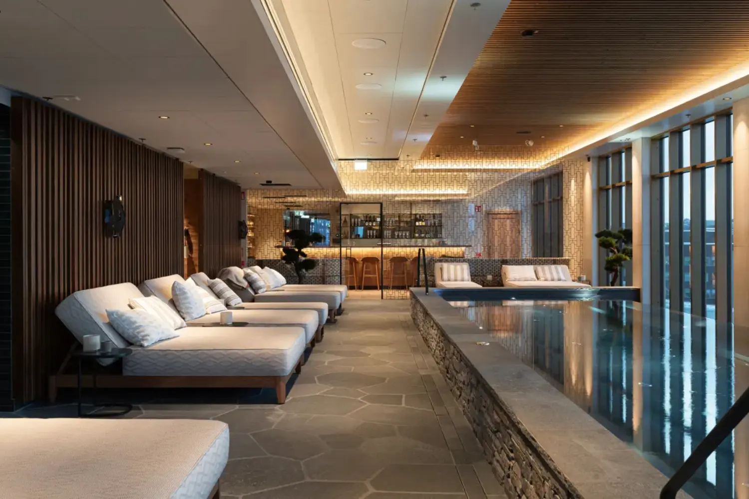 Vana Spa Elite Frost Kiruna The cozy indoor pool at Vana Spa, Elite Hotel Frost in Kiruna, surrounded by plush loungers and a stylish bar in the background."